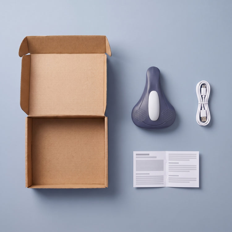 A plain open shipping box next to the NeuroPulse device, a USB-C cable and a folded quick-start guide
